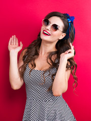 The girl in a red dress on a red background in the studio