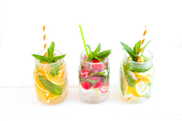 Homemade iced lemonade with mint, summer fruits and berries in a mason jar. Copy space background