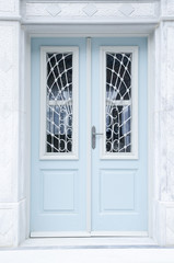 New blue wooden door on white wall, Greece