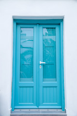 New blue wooden door on white wall, Santorini