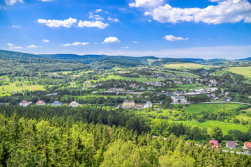 Fototapeta na wymiar Aerial view of rural scenery in mountain valley, town and houses in nature, green panoramic landscape