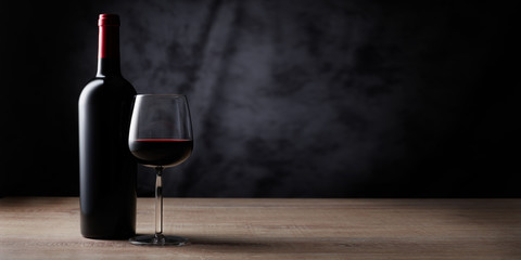 Rotweinflasche mit Weinglas auf Schwarz - obrazy, fototapety, plakaty