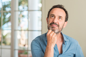 Handsome middle age man serious face thinking about question, very confused idea
