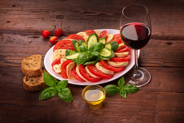 Caprese Salad. Tomato and Mozzarella slices with basil leaves with ciabatta bread. Snack for wine. Isolated on white background.