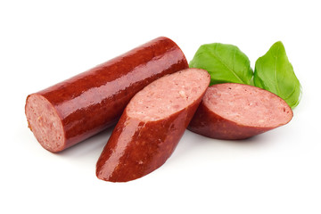 Sliced smoked sausage with fresh basil leaves, isolated on white background. Close-up.