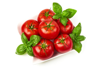 Fresh juicy tomatoes with basil leaf, isolated on white background. Close-up.