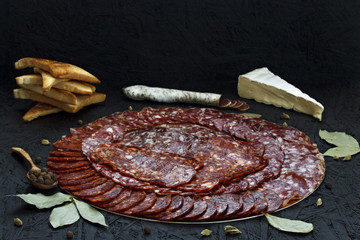 Assorted different types of cheese sausage on a dark background.