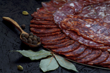 Assorted different types of cheese sausage on a dark background.