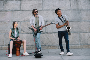 Multiracial young people performing in band on street
