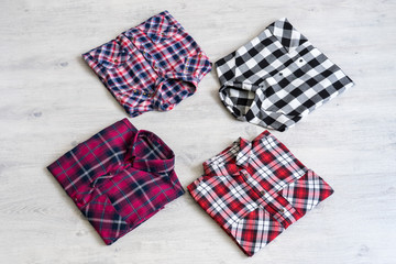 Four multi-colored checkered women's shirts lying neatly folded
