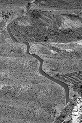 Lanzarote, Canary Islands, Spain, elevated landscape view of picturesque curvy country road going diagonally through deserted land, black and white picture