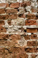 Cracked vintage orange brick wall with white patina close-up