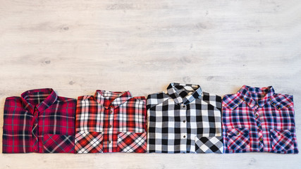 Four multi-colored checkered women's shirts lying neatly folded