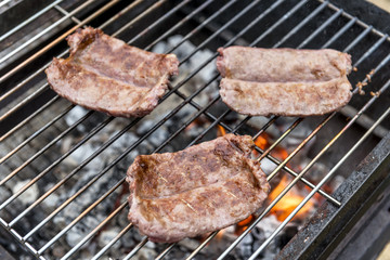 Sausages cook on the grill