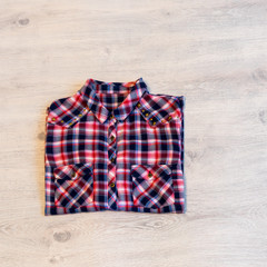 Multi-colored checkered women's shirt lying neatly folded on a l