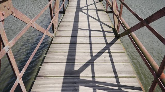 Walking over the bridge wooden boards slow motion glide camera