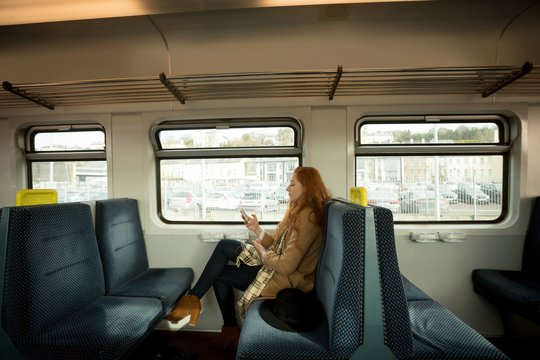 Woman using mobile phone while travelling in train