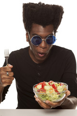 young handsome afro american guy eat salad isolated on white background. healthy food concept