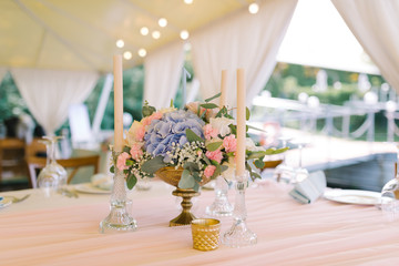 Beautiful wedding decor on round tables in gentle flowers