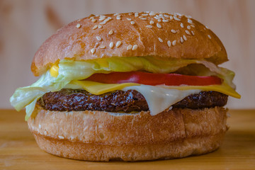Delicious and juicy burger with appetizing meatball and fresh vegetables