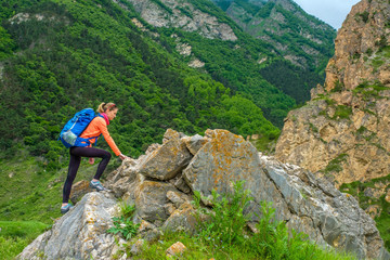 Girl with a backpack in the mountains.