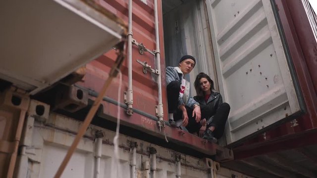 Young couple sitting in the container.