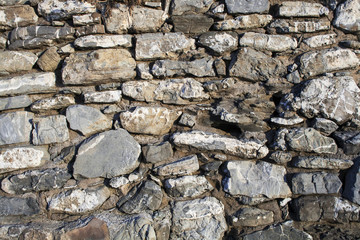Background with several gray stones. Close-up of large stones, which are connected by cement with one another.