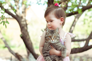 Happy little girl playing with kitten