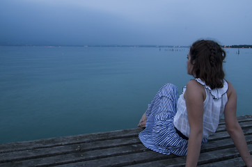 Girl looking at the sea from a pier