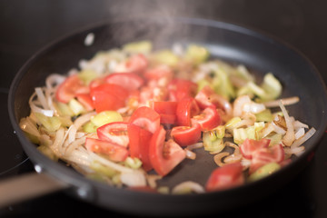 Green peppers onion and tomato on the grilled pan. Healthy breakfast.
