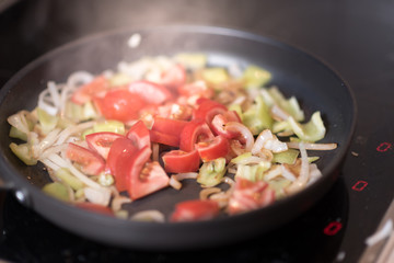 Green peppers onion and tomato on the grilled pan. Healthy breakfast.