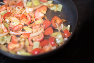 Green peppers onion and tomato on the grilled pan. Healthy breakfast.