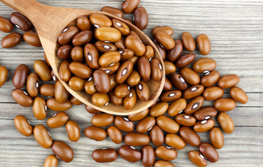 Haricot beans in a wooden spoon on wooden background