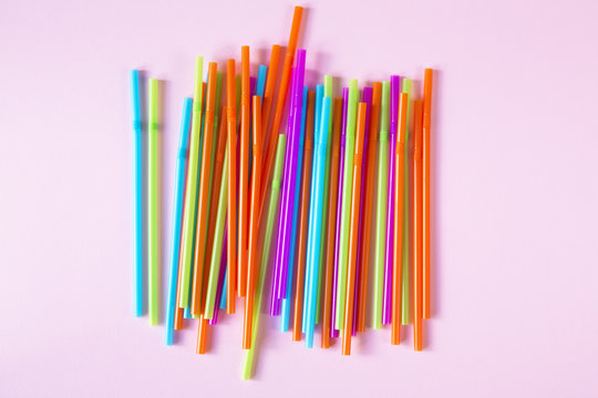 Colorful straws on a pink background