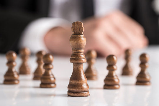 Businessman planning strategy with dark chess figures