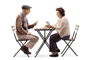 Obraz premium Seniors sitting at a table and playing cards