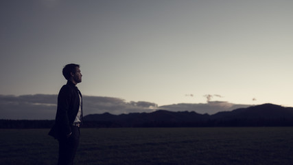 Fototapeta premium Businessman celebrating a new day standing in his business suit outside in nature