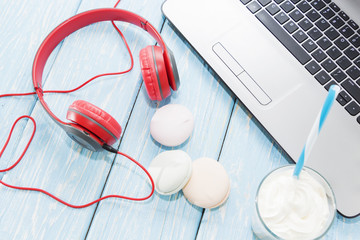 open laptop with white Cup of coffee, marshmallows and red headphones.