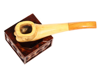 Wooden smoking pipe in form of a smiling face on a ashtray. Isolated on a white