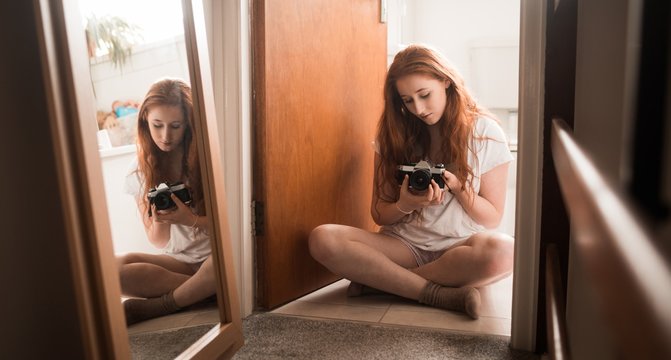 Woman holding camera at home