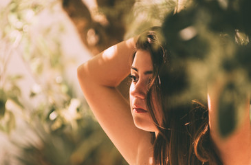 beautiful teen girl enjoying of the Sun among the branches of a forest
