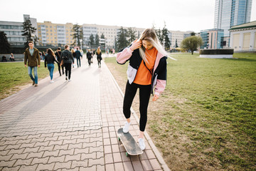 Portrait of a girl with a skateboard, outdoors