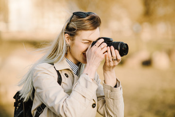 Portrait of a beautiful young blond woman with a camera, lifestyle