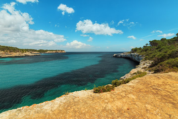 Obraz premium Cala Mondrago natural park landscape view. Beautiful cove with turquoise crystal waters in Cala s'Amarador Mediterranean Sea. Travel concept.