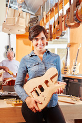 Junge Frau als Gitarrenbauer Azubi