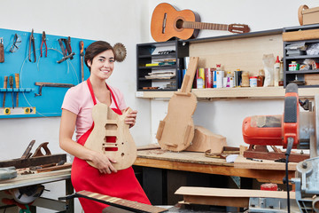 Frau zeigt eine handgefertigte Gitarre