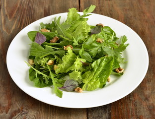 Fresh green salad with spinach, arugula, lettuce, herbs and nuts