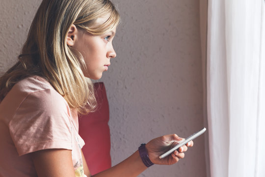  blond girl in pink t-shirt using smartphone