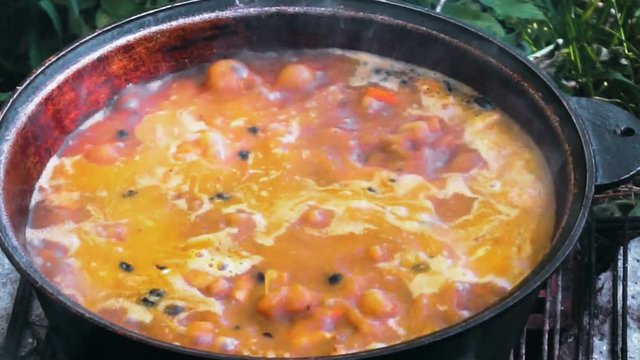 hot boiling liquid soup in a cauldron close up.
