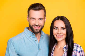 Head shot portrait of trendy attractive couple with beaming white smiles isolated on bright yellow background. Love story true feelings concept